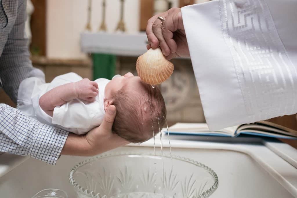 baby being baptized with water
