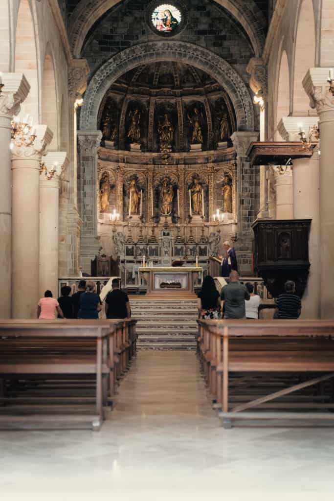 people sitting on brown wooden bench inside cathedral